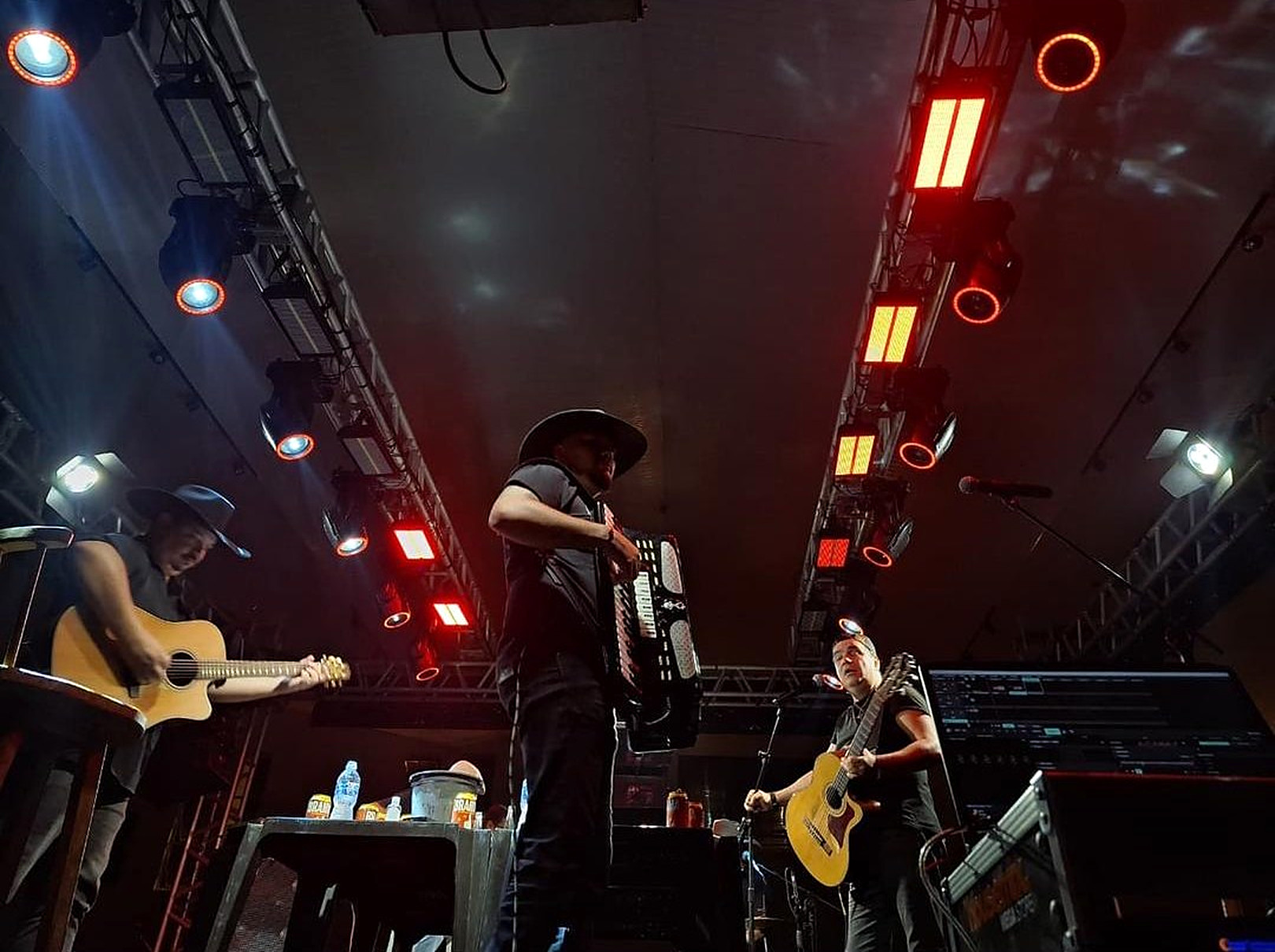 Músicos no palco sob iluminação vermelha